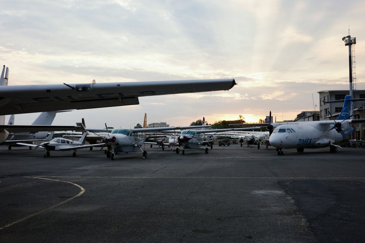 Small airplanes parked on an African airport tarmac at sunset
