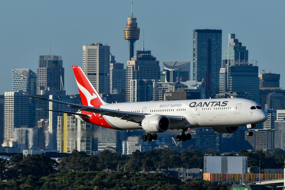 Large passenger jet flying over city near Sydney airport