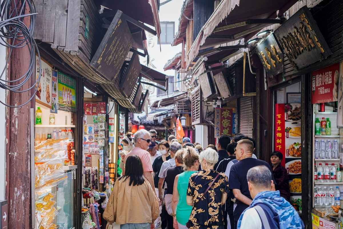 Crowded street market with tourists browsing stalls