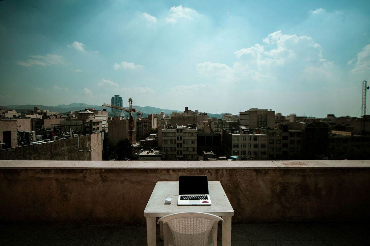 Laptop on a table overlooking a city skyline, remote work scene