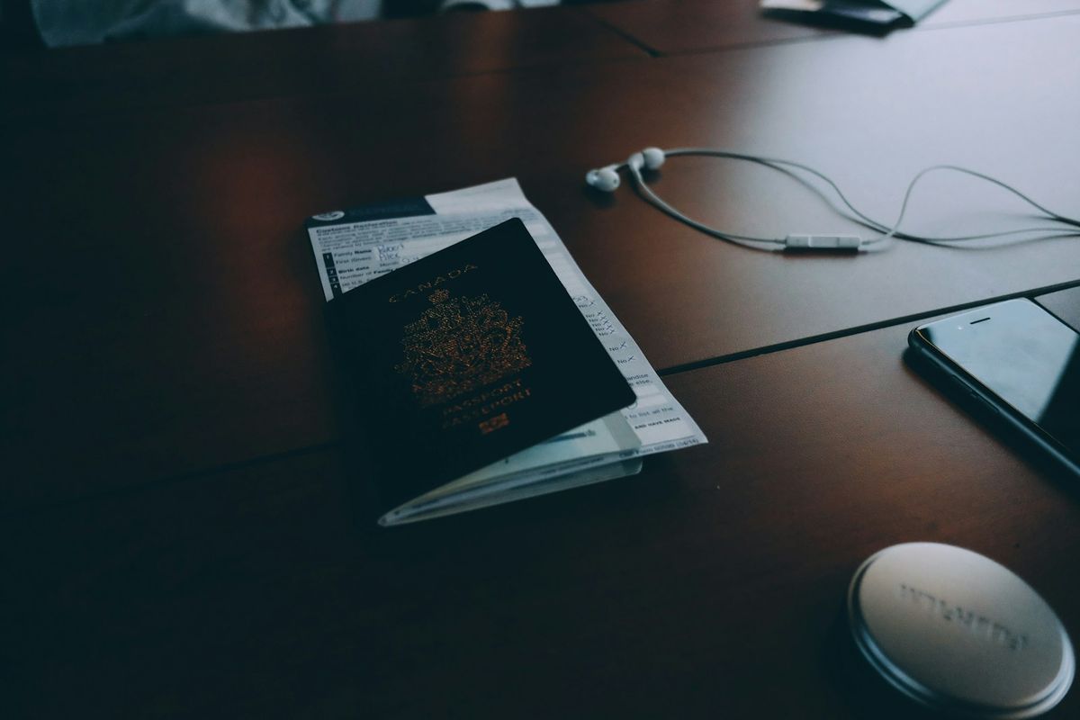 Passport next to a pair of earphones