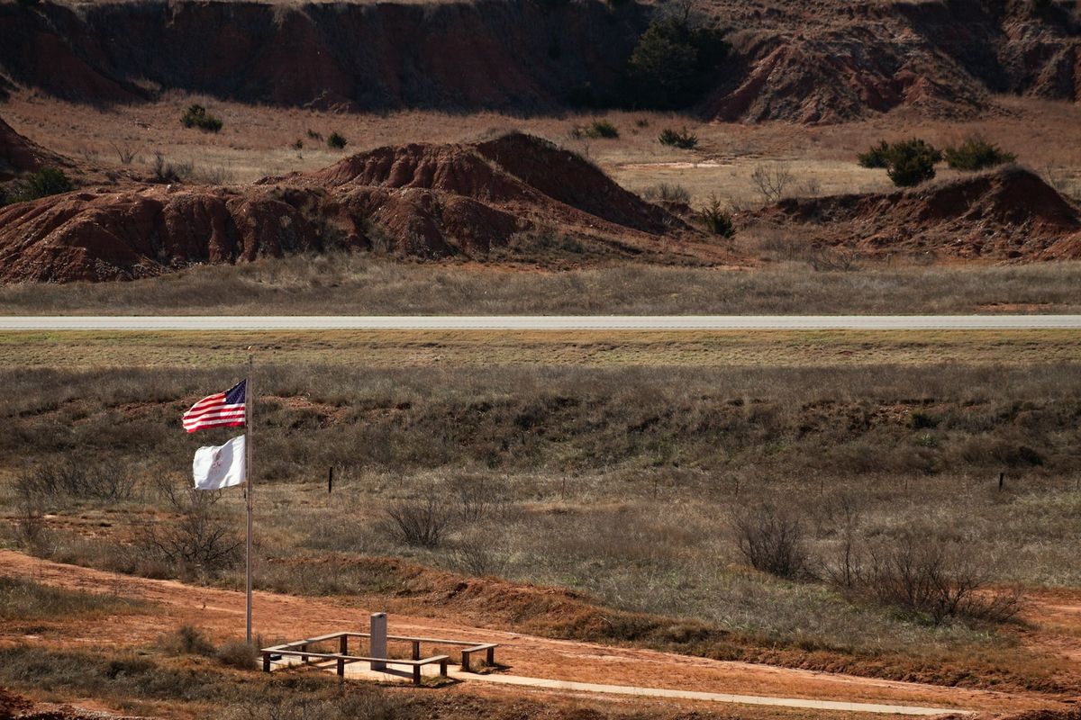 American flag flying over a desert border landscape in the United States