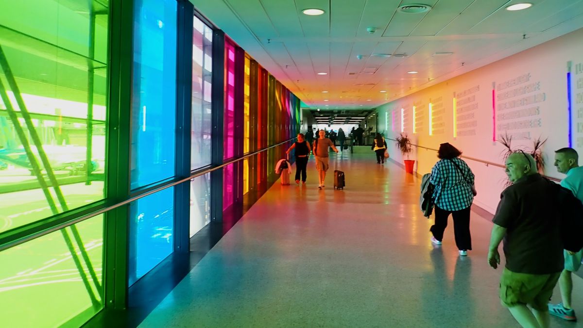 People walking through a vibrant colourful airport walkway