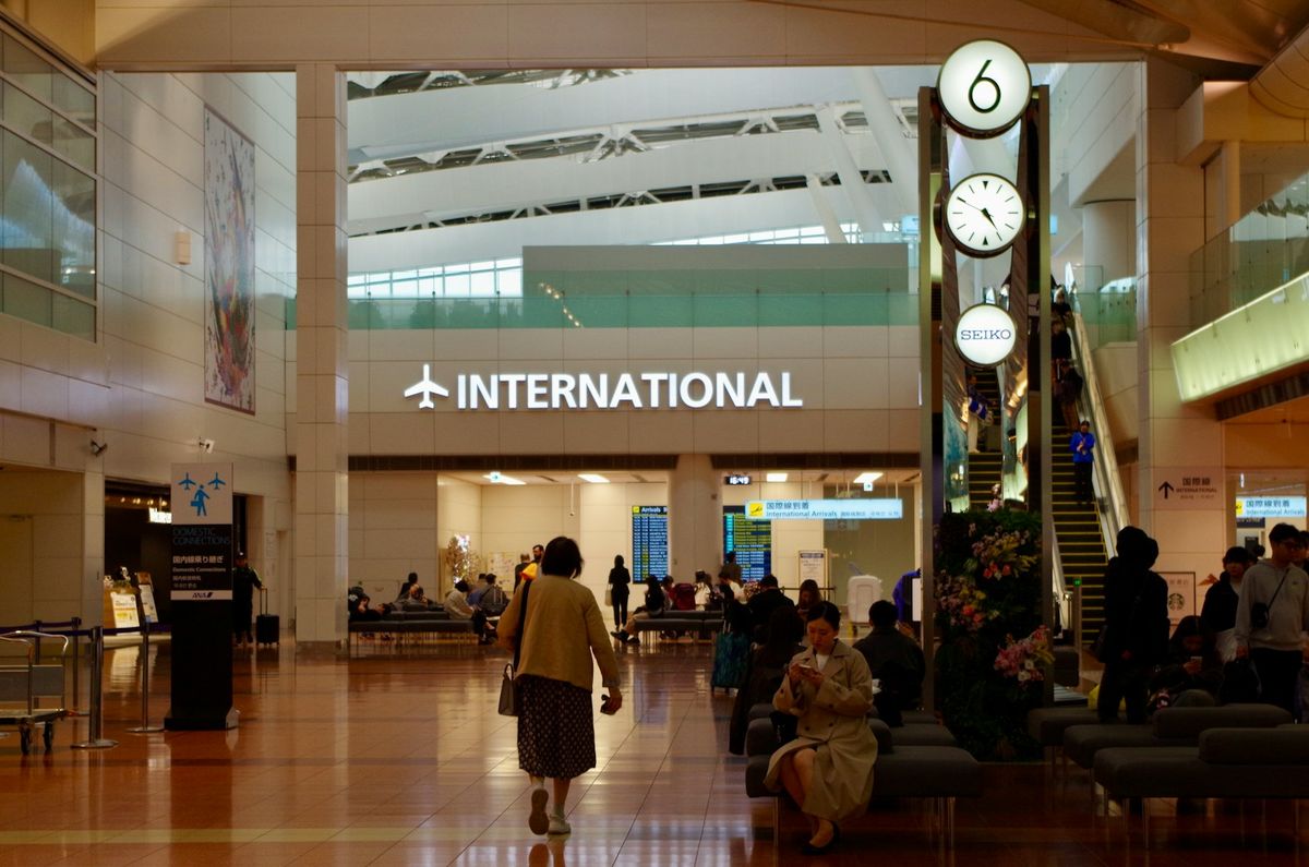 Airport departure hall with clocks and passengers