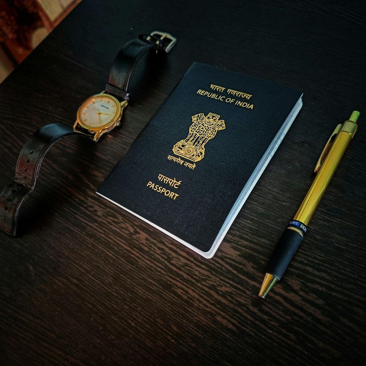 Passport with a watch and pen on a table, planning travel dates