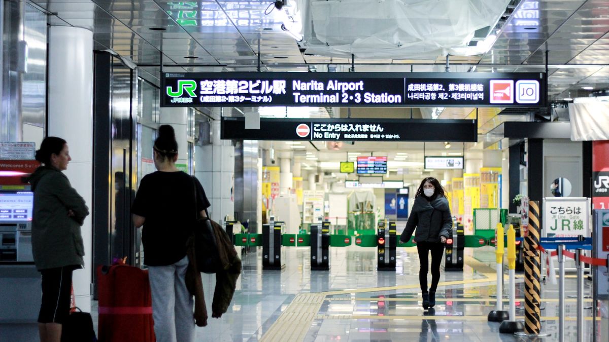 Travelers walking through an airport arrivals hall in Japan