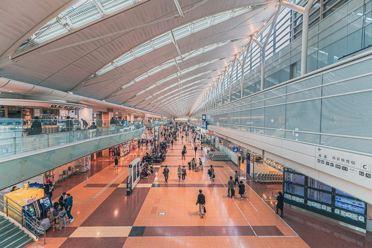 Travelers walking through an international airport terminal corridor