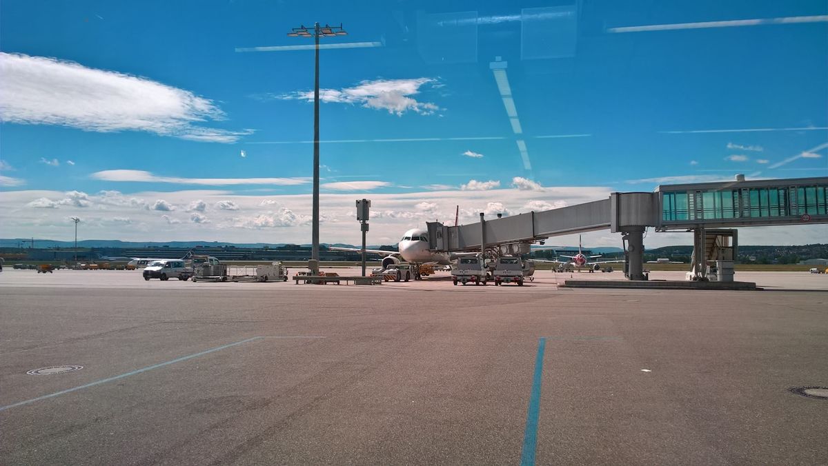 Airplane connected to a jet bridge at the boarding gate