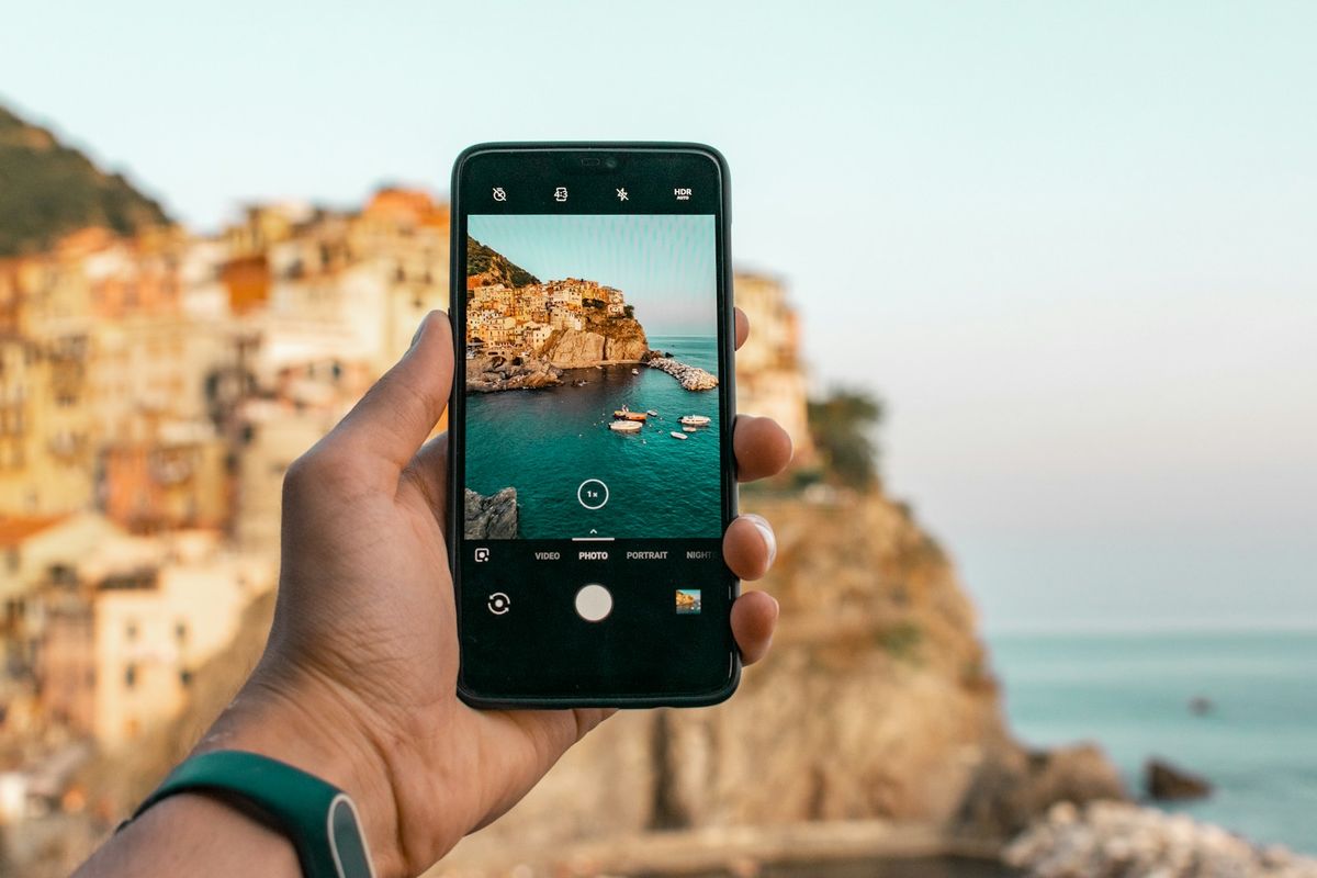 Traveler checking their phone signal abroad near a scenic viewpoint