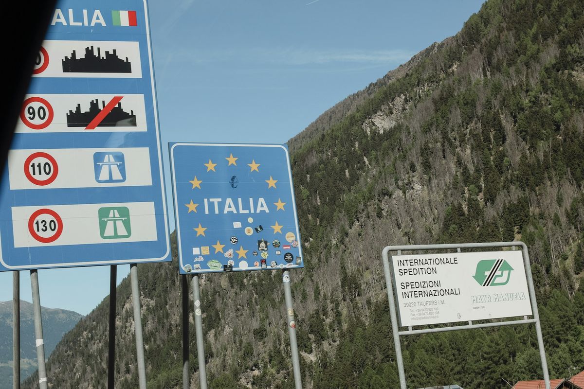 Road signs for Italy and EU at a mountain border