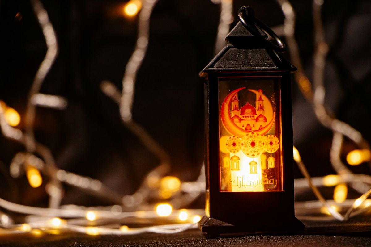Lit lantern with festive Ramadan lights in the evening