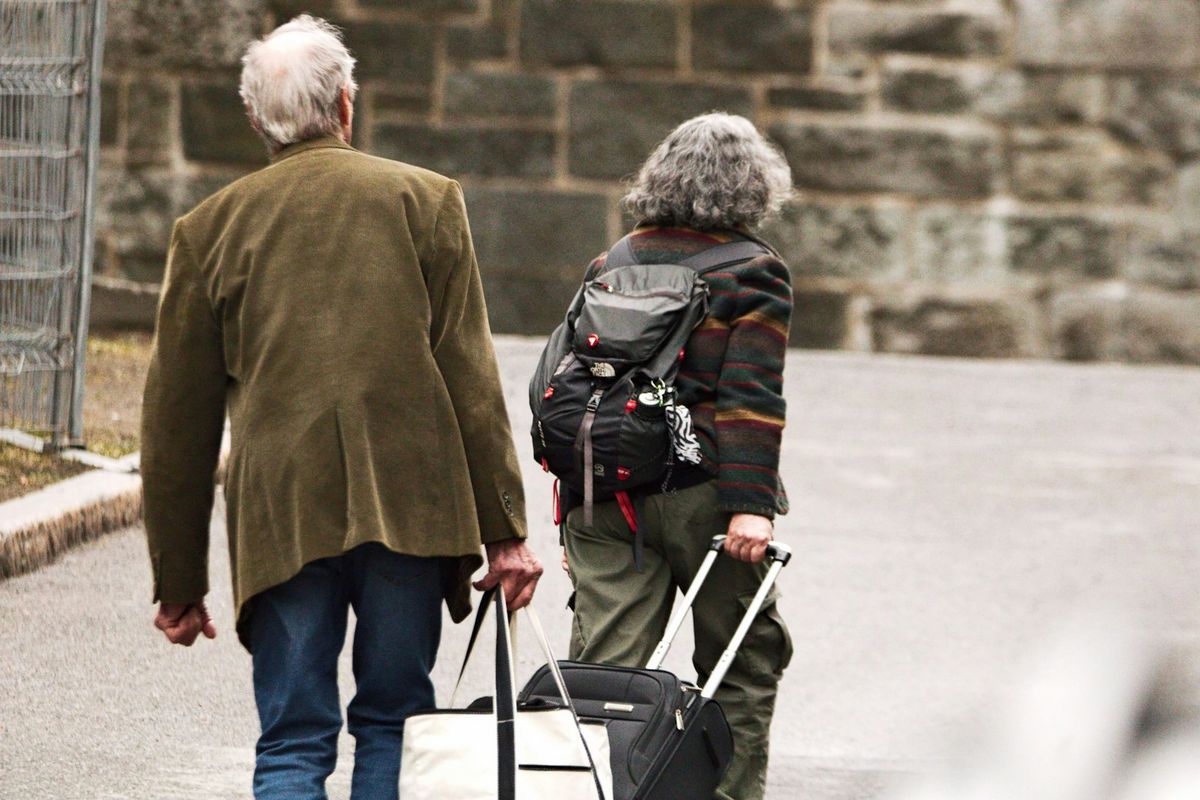 An older couple walking with luggage