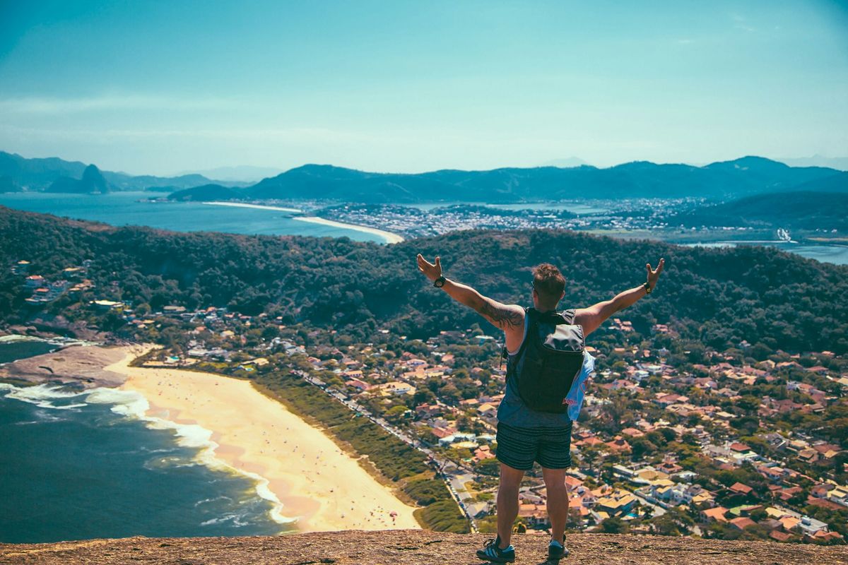 Young man at coastal scenery with houses in background