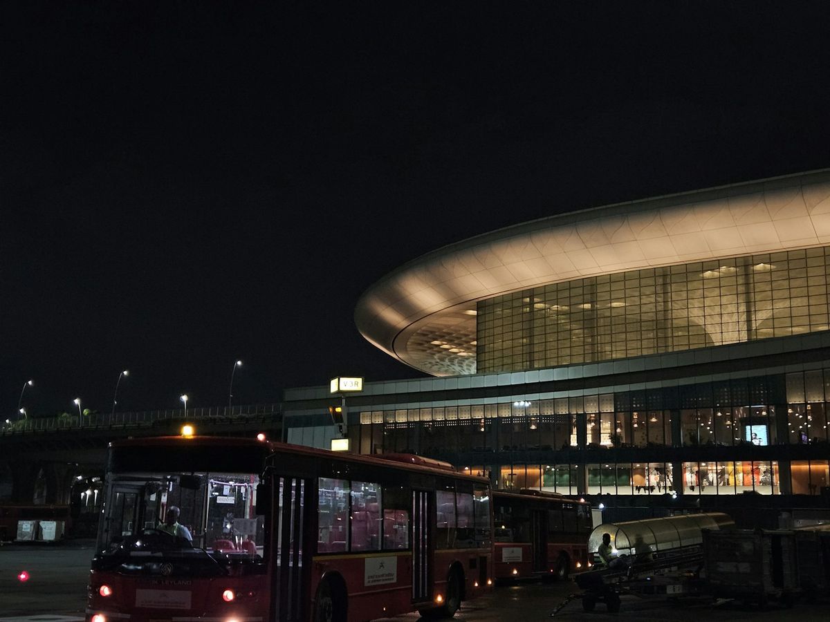 Airport terminal entrance at night with shuttle bus