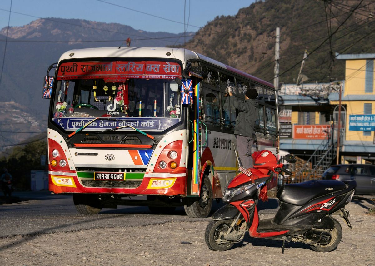 Colorful local bus on a winding mountain road in Nepal