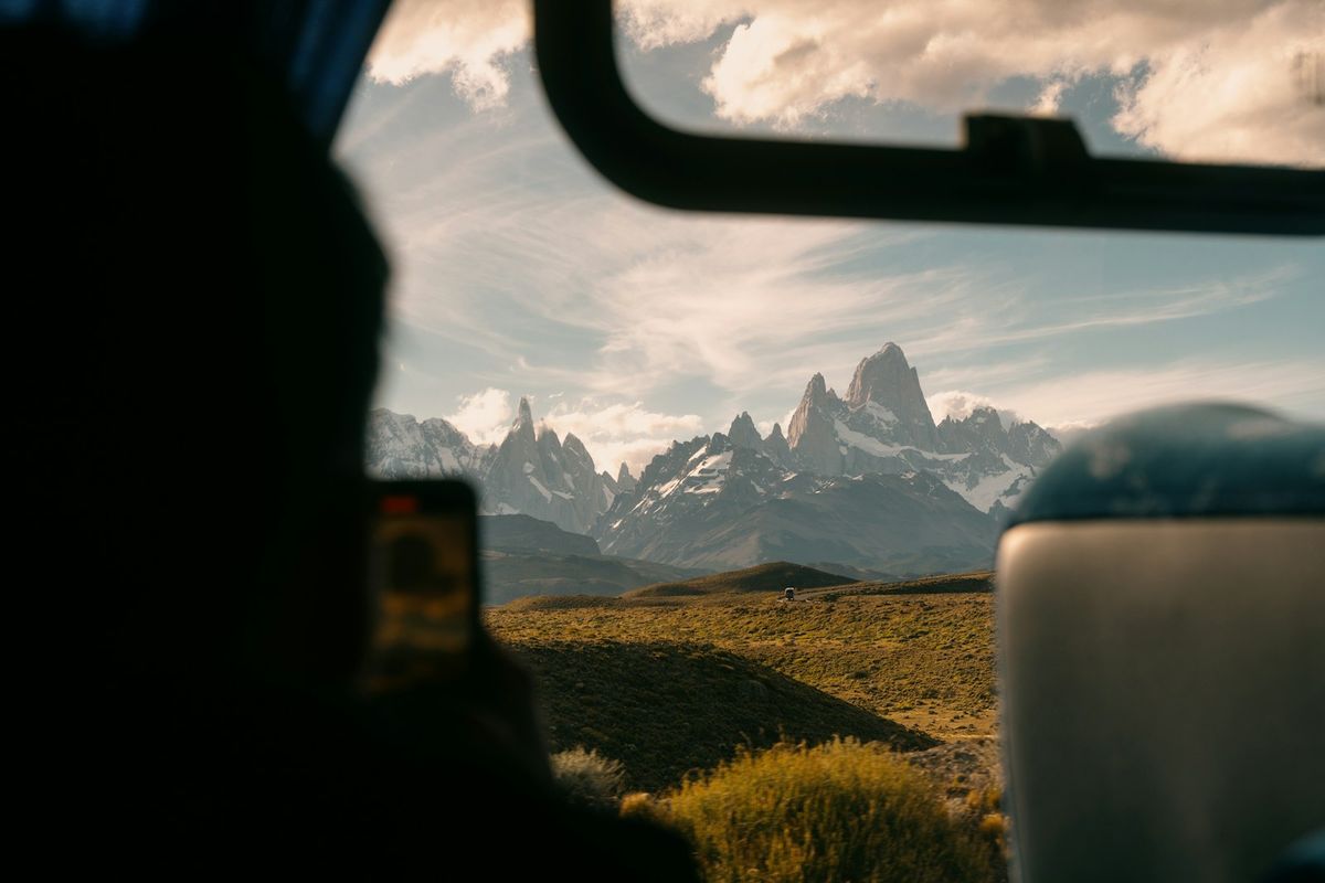Snow-capped mountains viewed from a moving bus window