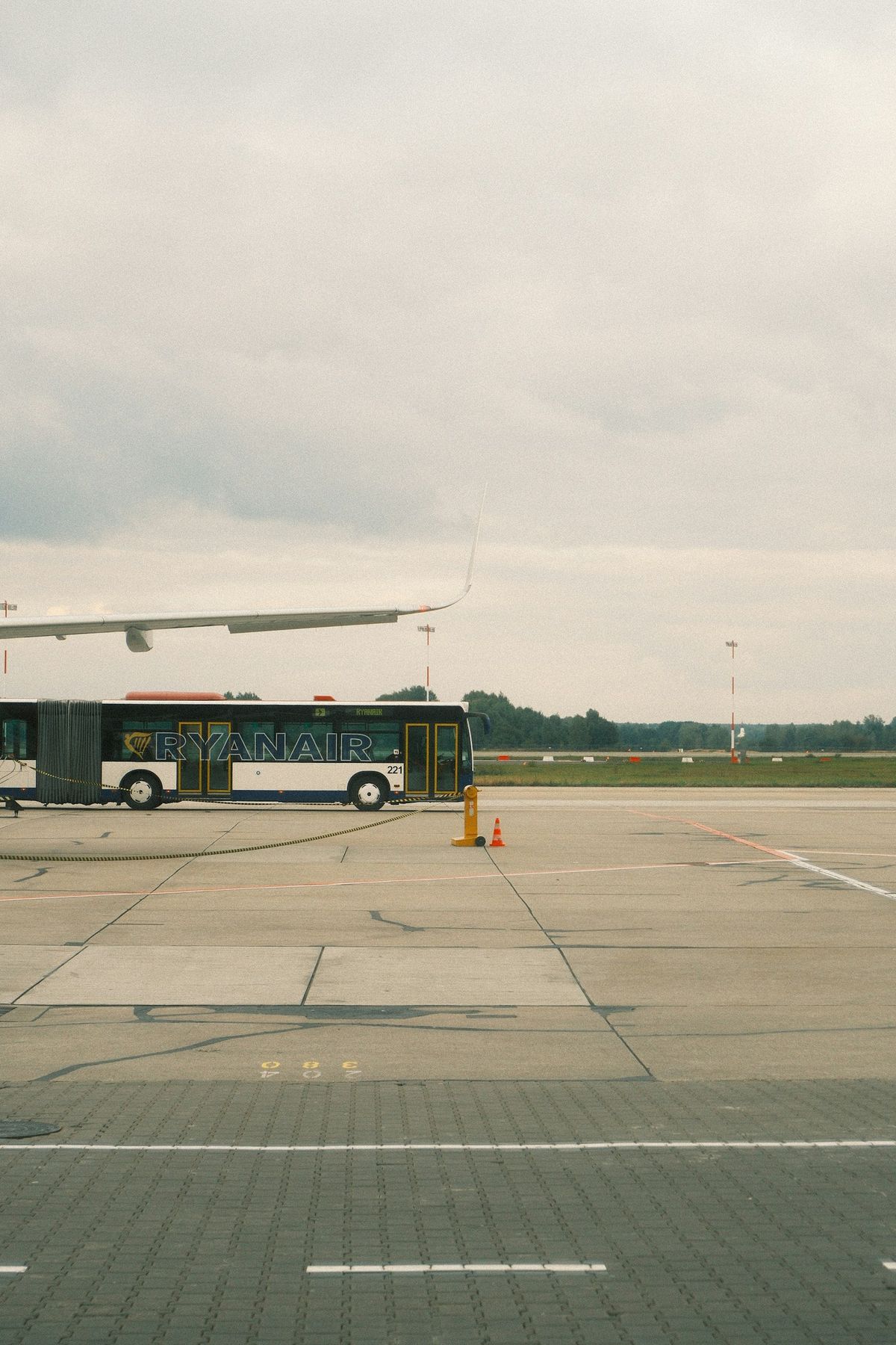 Ryanair bus on airport tarmac next to airplane wing