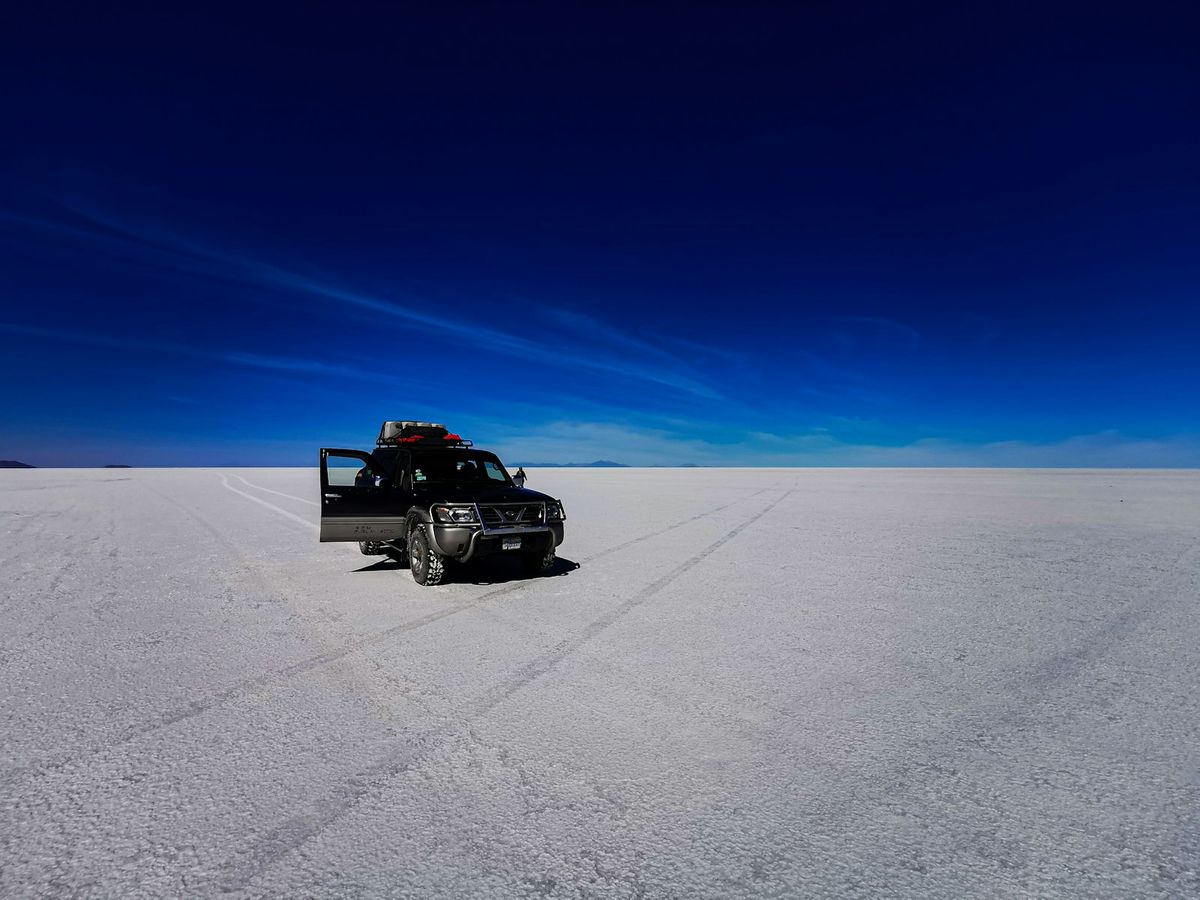 A vehicle crossing the vast open plains of the Bolivian altiplano
