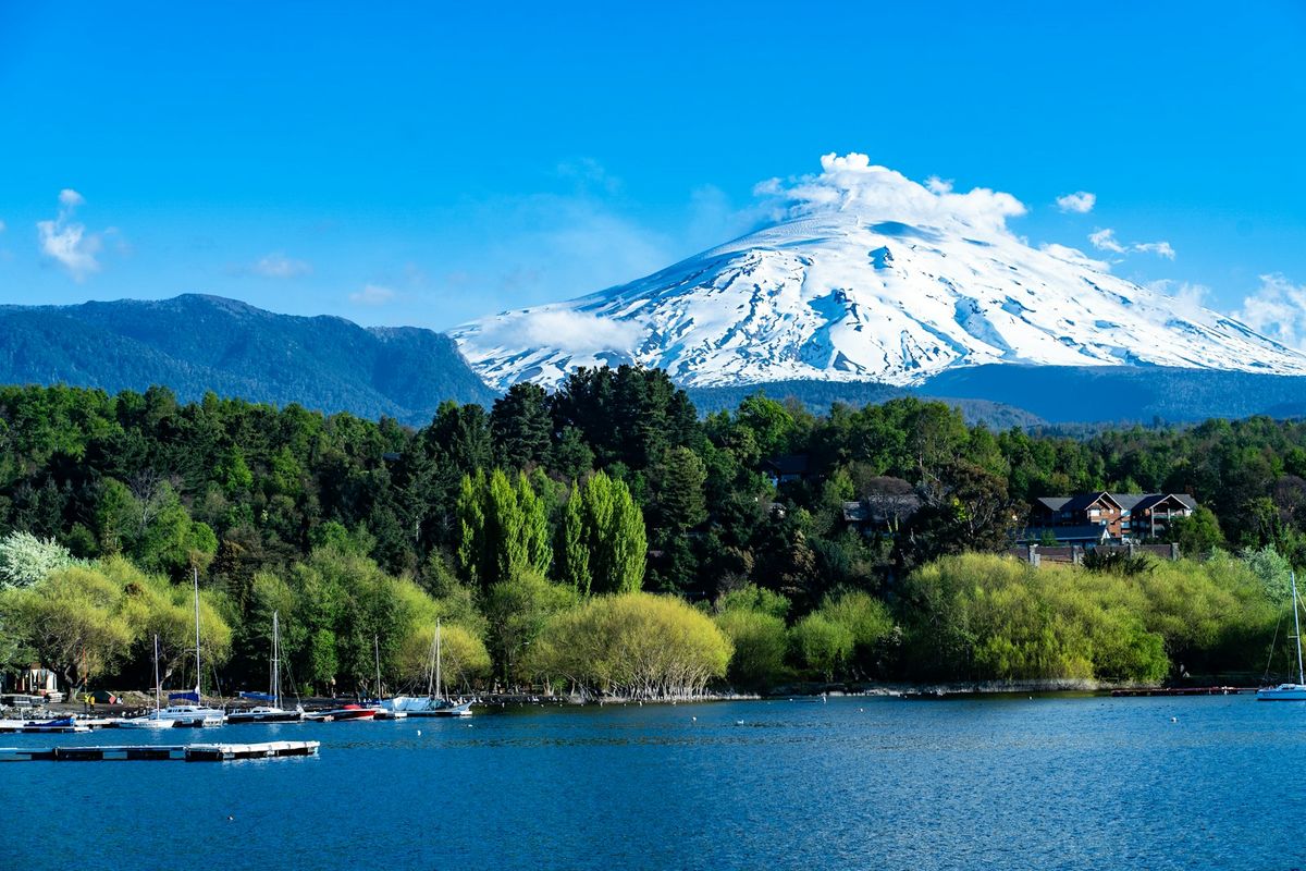 Lake with boats and volcano backdrop in Chile's Lake District