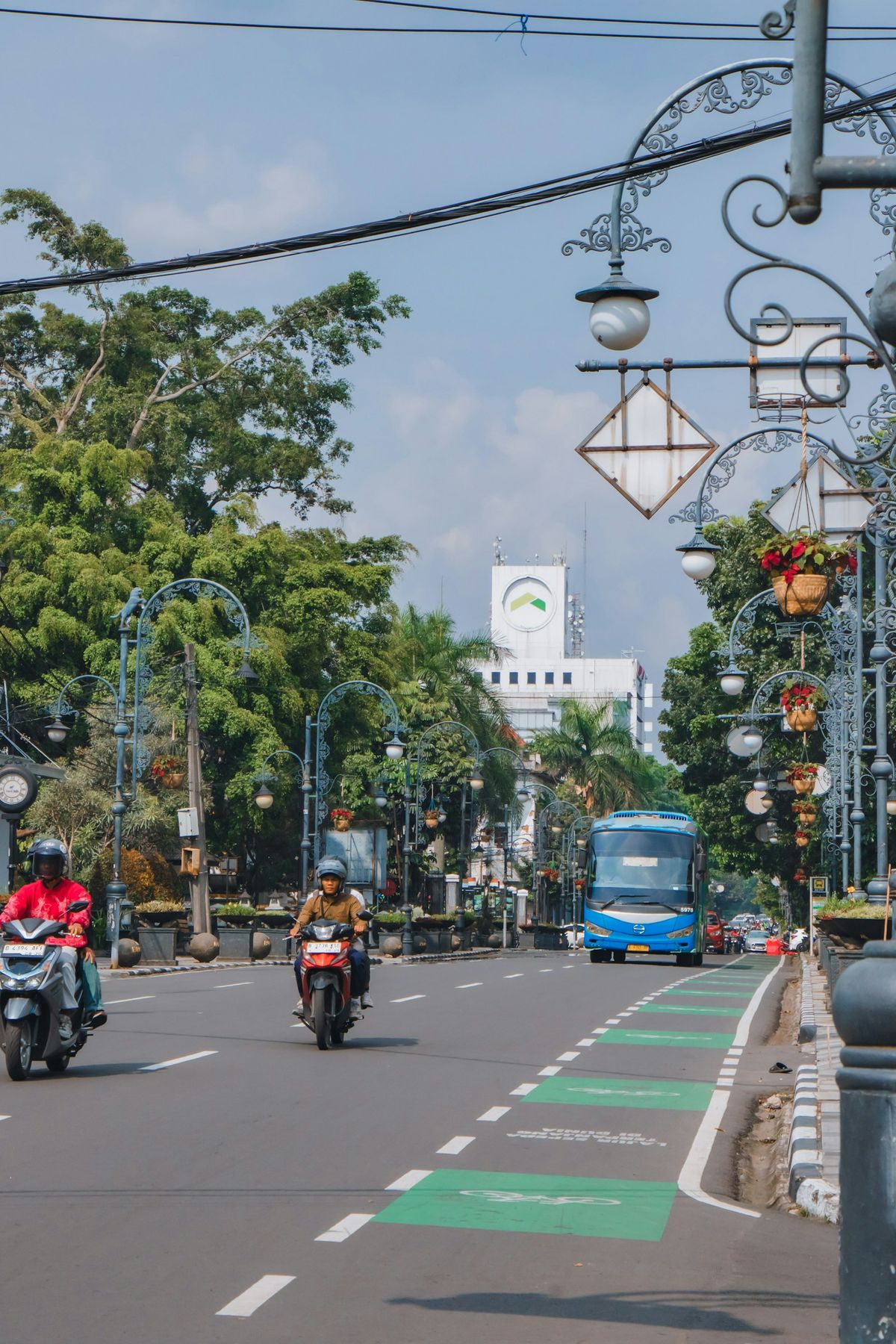 Intercity bus on a tree-lined street in Yogyakarta, Indonesia