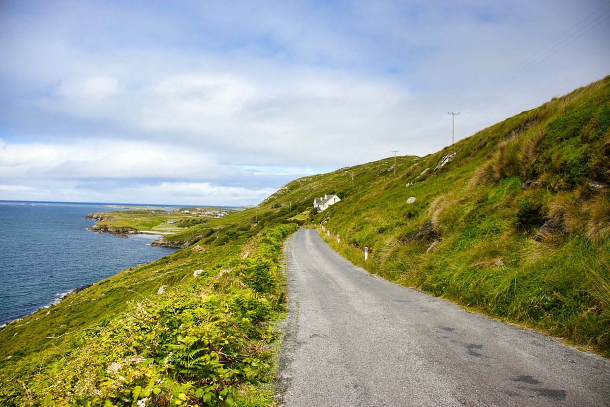 Winding coastal road through green Irish hillsides