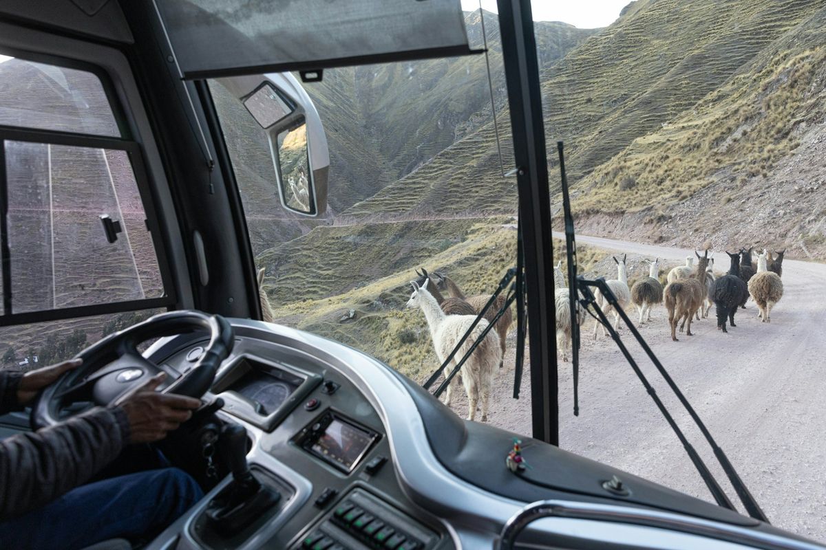 A bus driving on a dirt mountain road in the Peruvian Andes