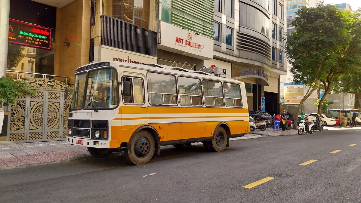 Yellow and white coach bus parked by the road in Southeast Asia