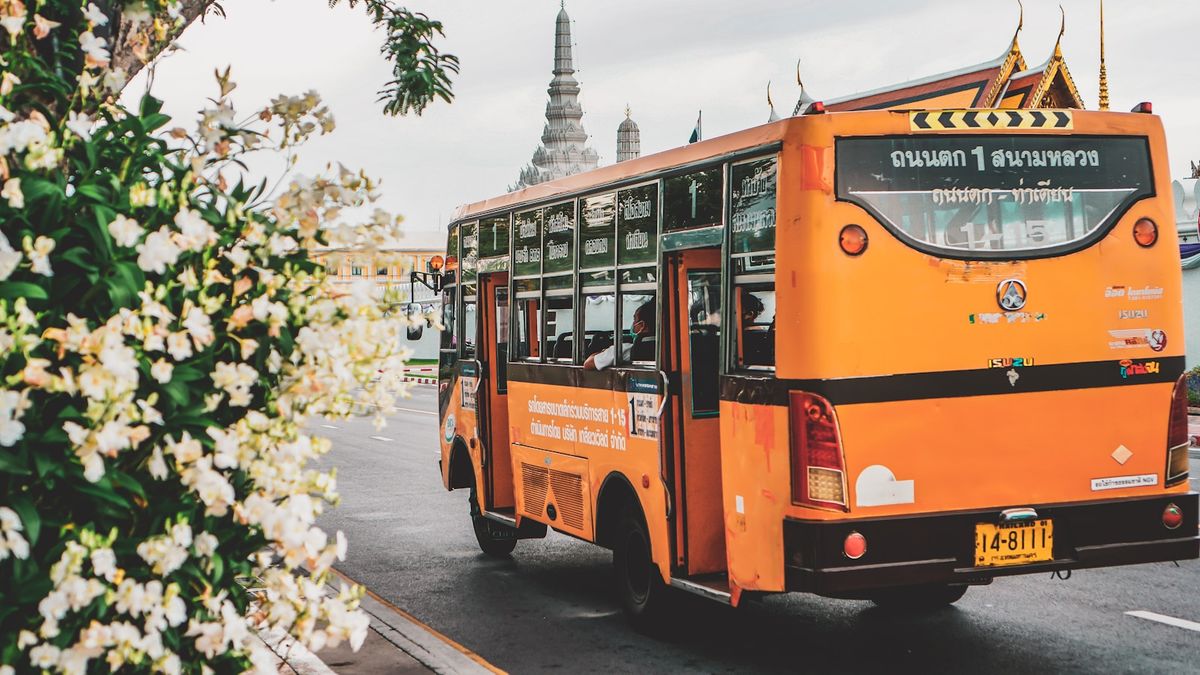 A bus travels down a street in Thailand