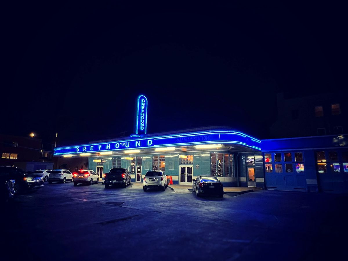 A Greyhound bus terminal building at night in the USA