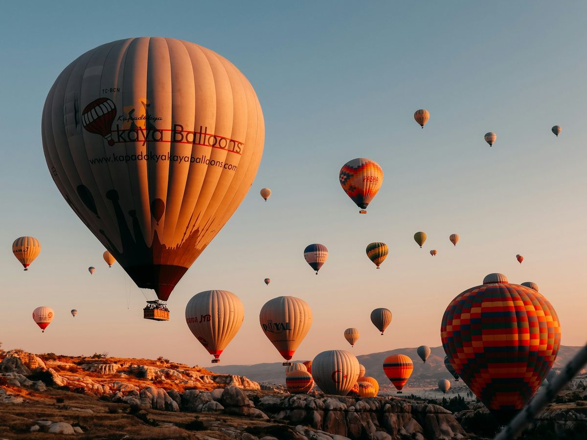 Hot air balloons on a brown field in Cappadocia at dawn, Turkey