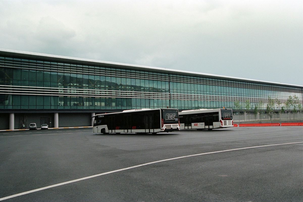Two coaches parked in front of a large European building