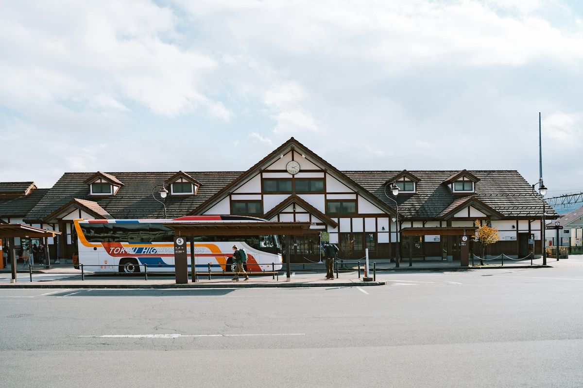 Highway bus at a traditional Japanese bus terminal with mountains