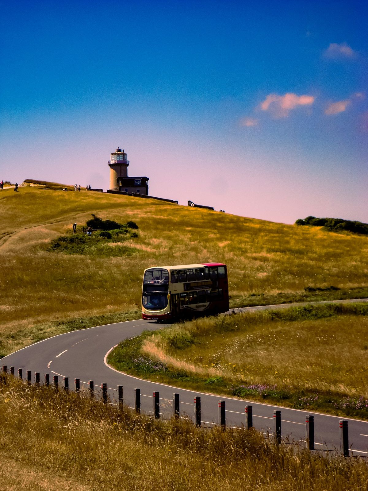 Bus traveling along road by a lighthouse