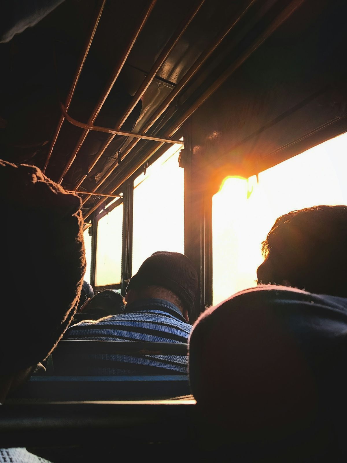 Passengers inside a bus watching the sunset through windows