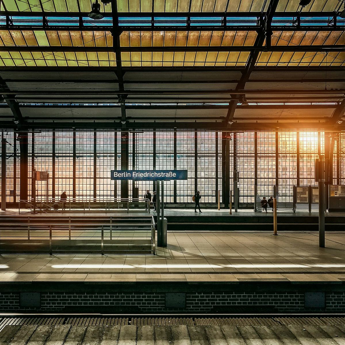 Passengers on a U-Bahn platform in Berlin during golden hour