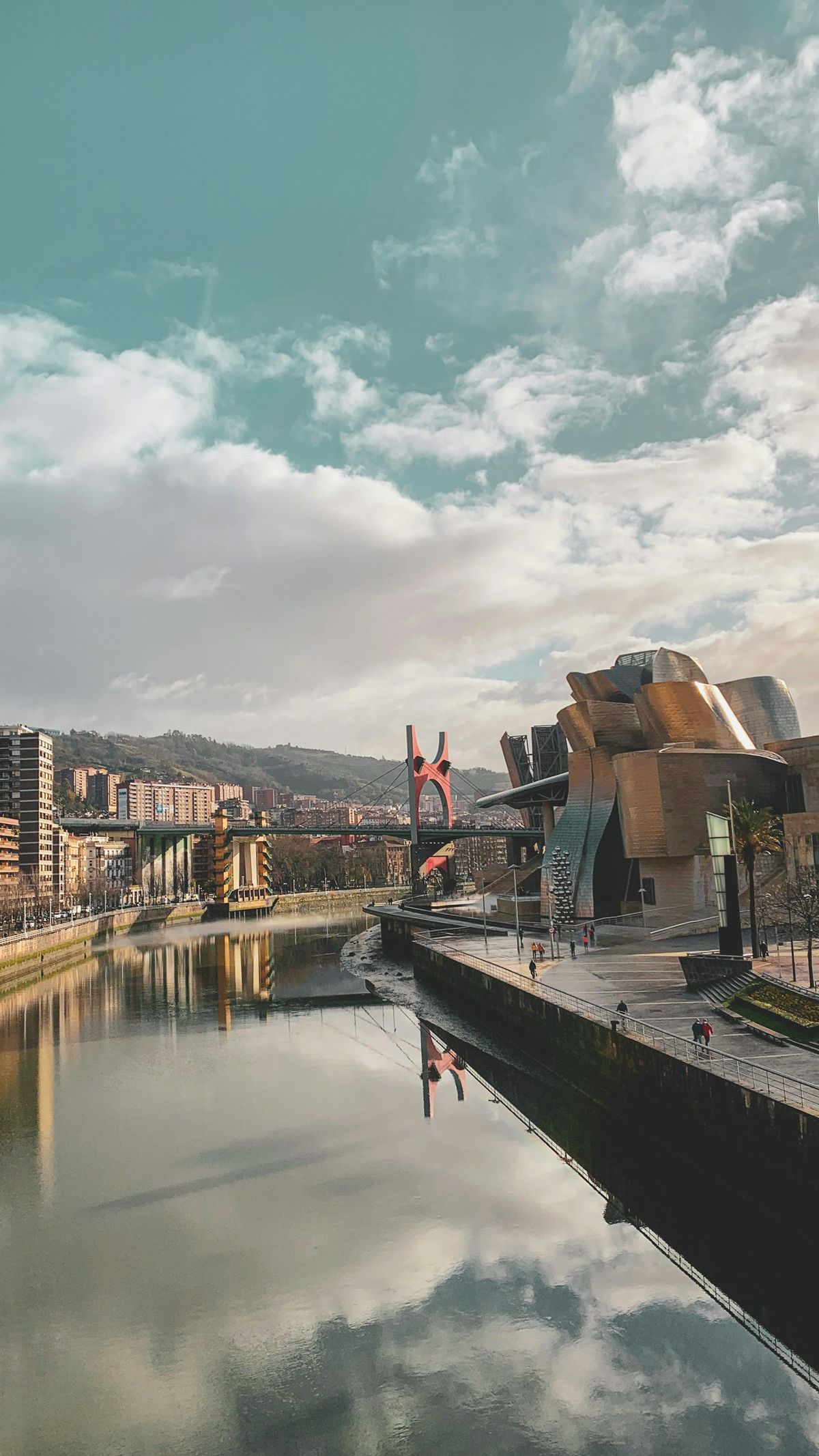 Buildings along Bilbao waterfront with white clouds Basque Country