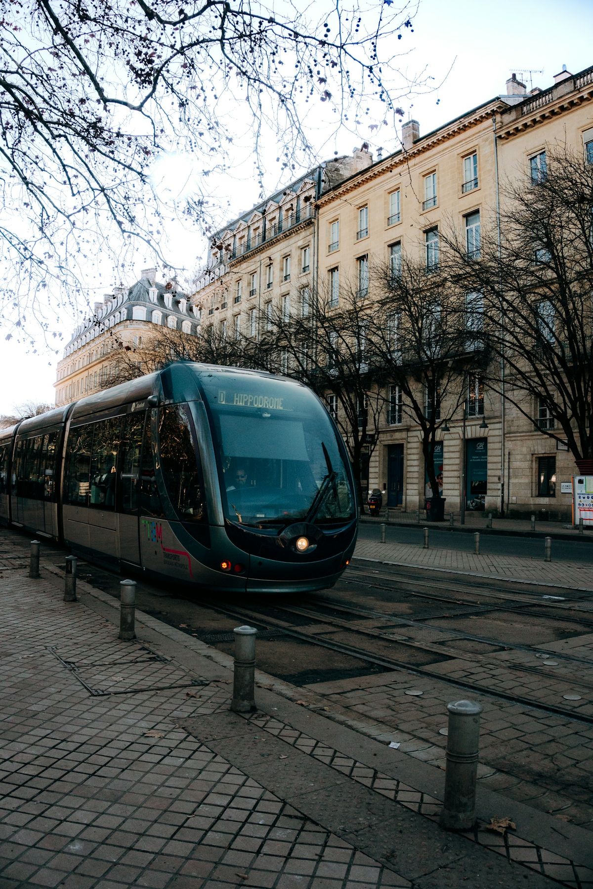 Tram travelling down a street lined with tall buildings in Bordeaux
