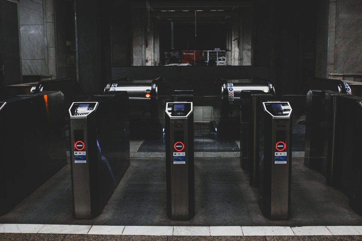 A row of transit turnstile gates at a subway station entrance