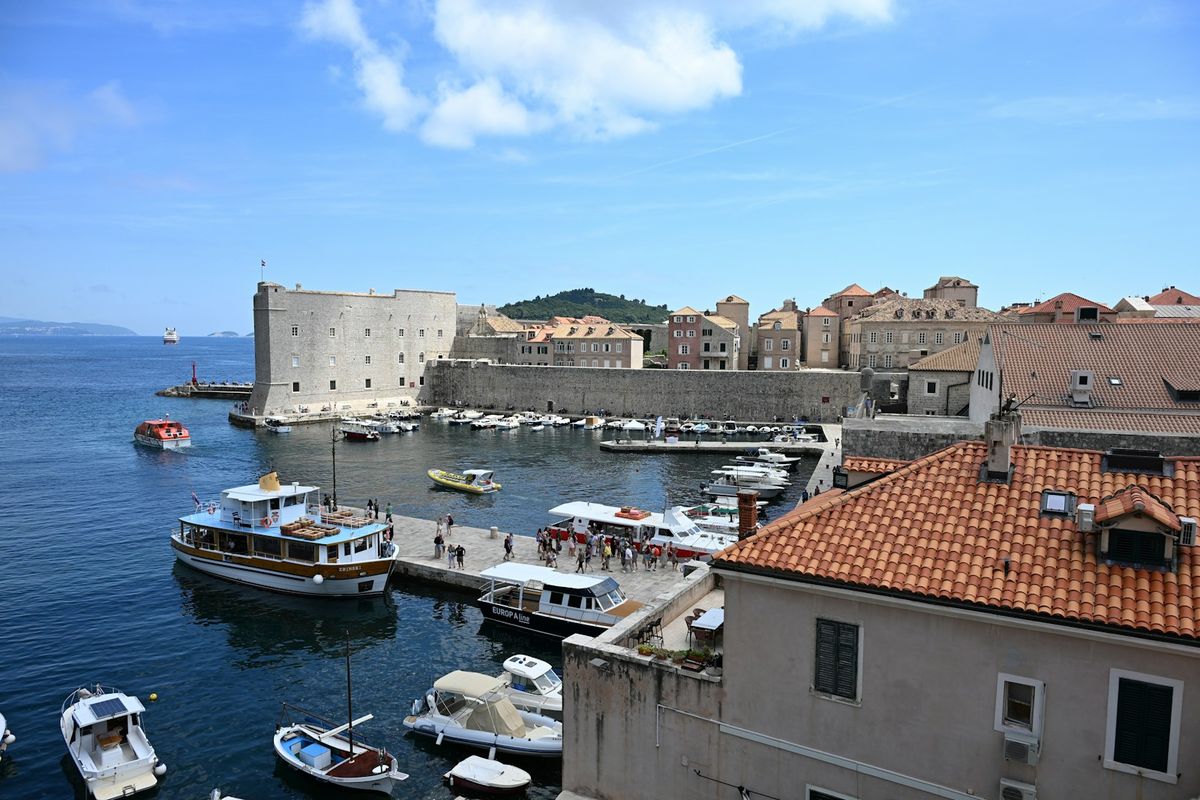 Historic Dubrovnik harbor with city walls and boats