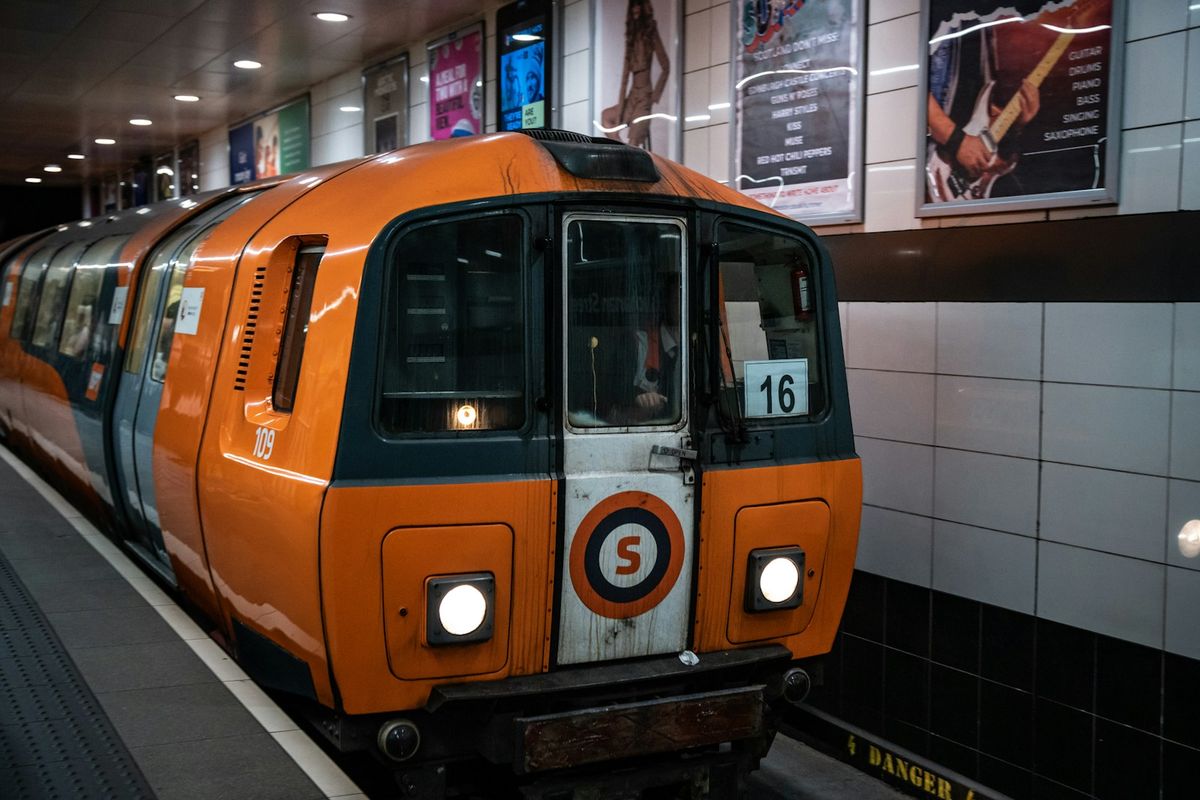 Orange Glasgow Subway train arriving at station platform