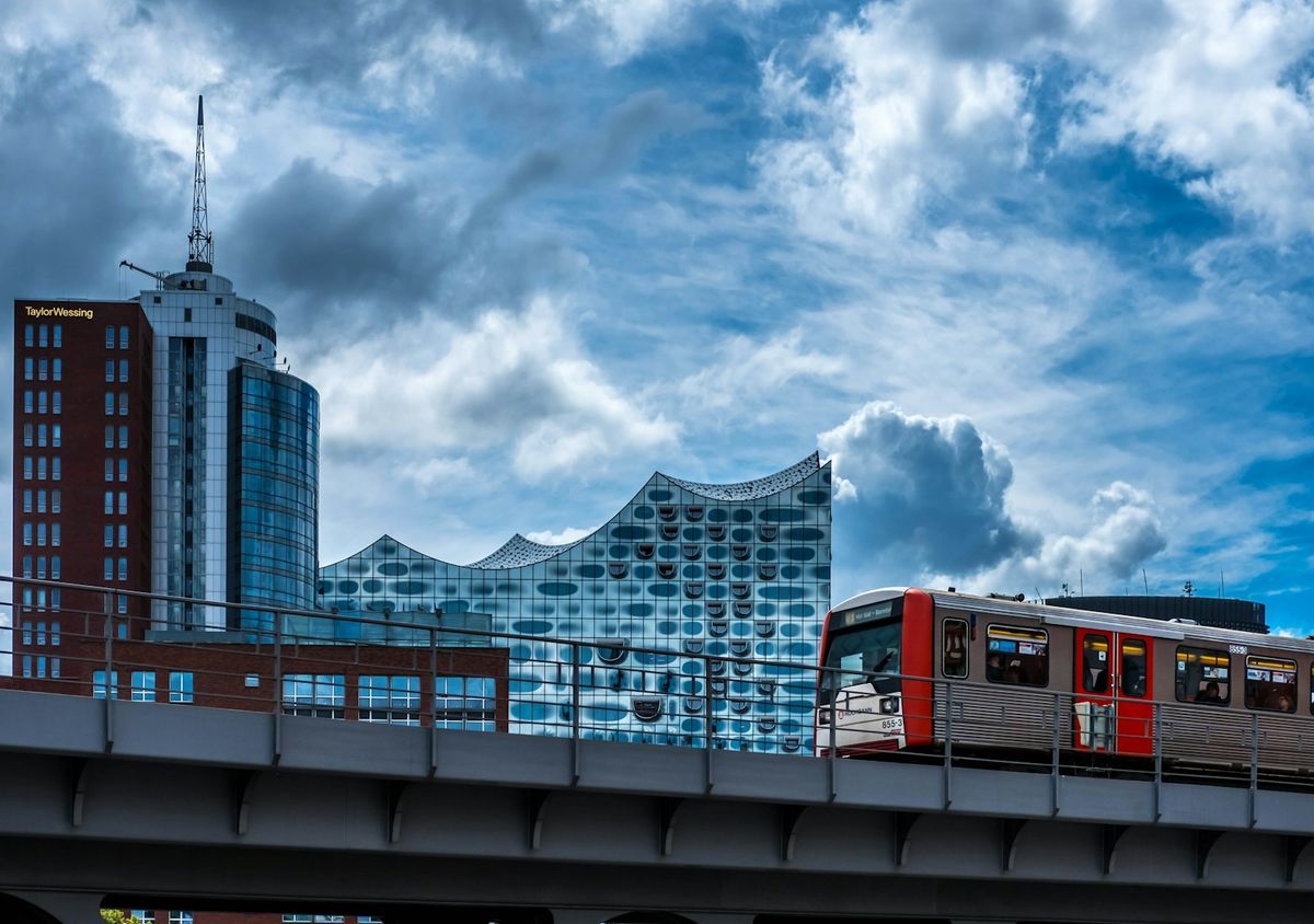 Train running on elevated rail near Hamburg city buildings
