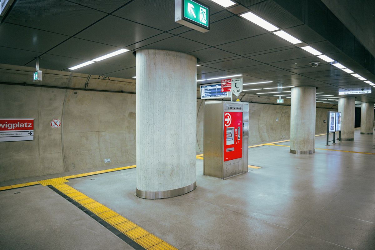 A modern subway station concourse with ticket gates