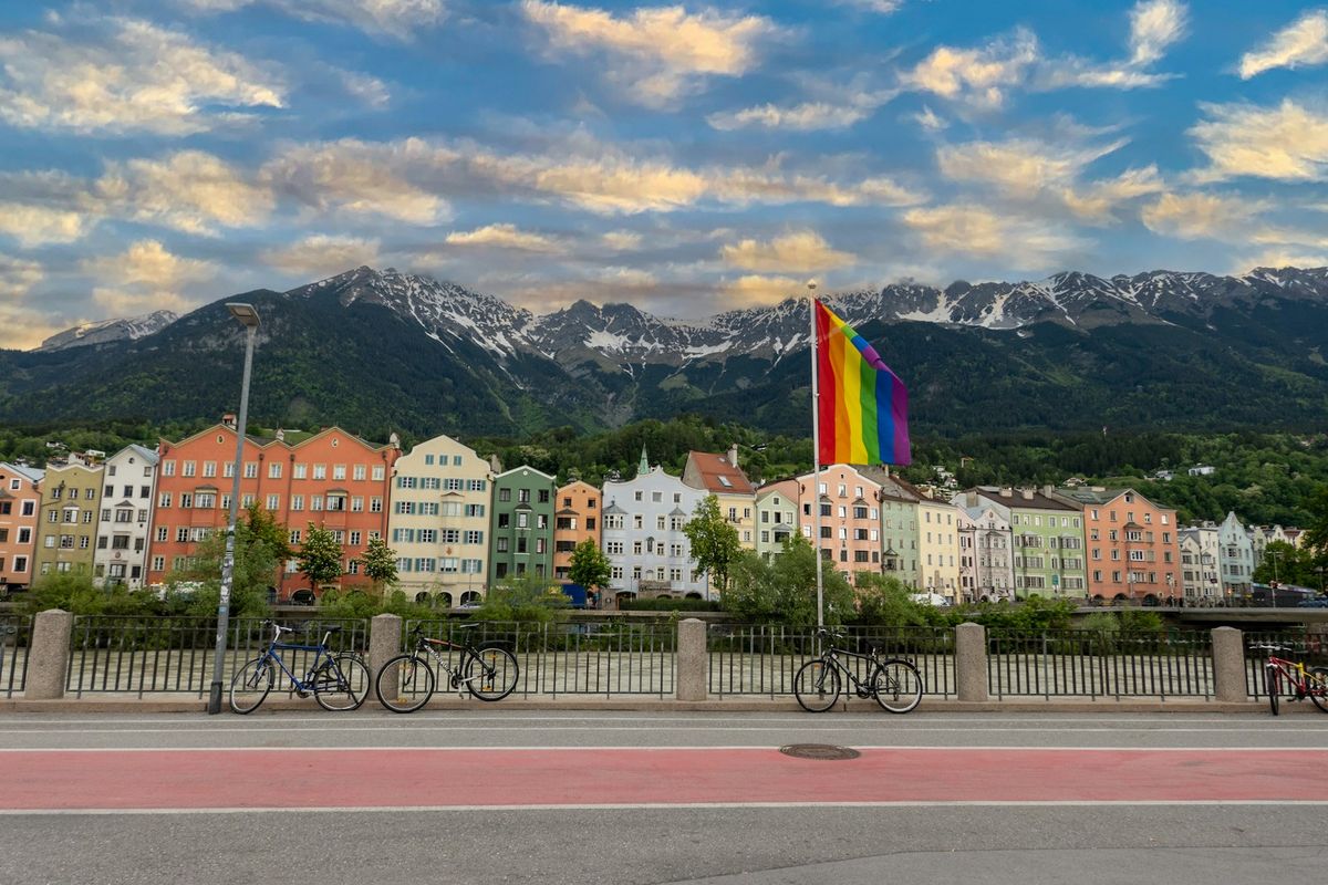 Colorful houses along the Inn river in Innsbruck with mountains behind