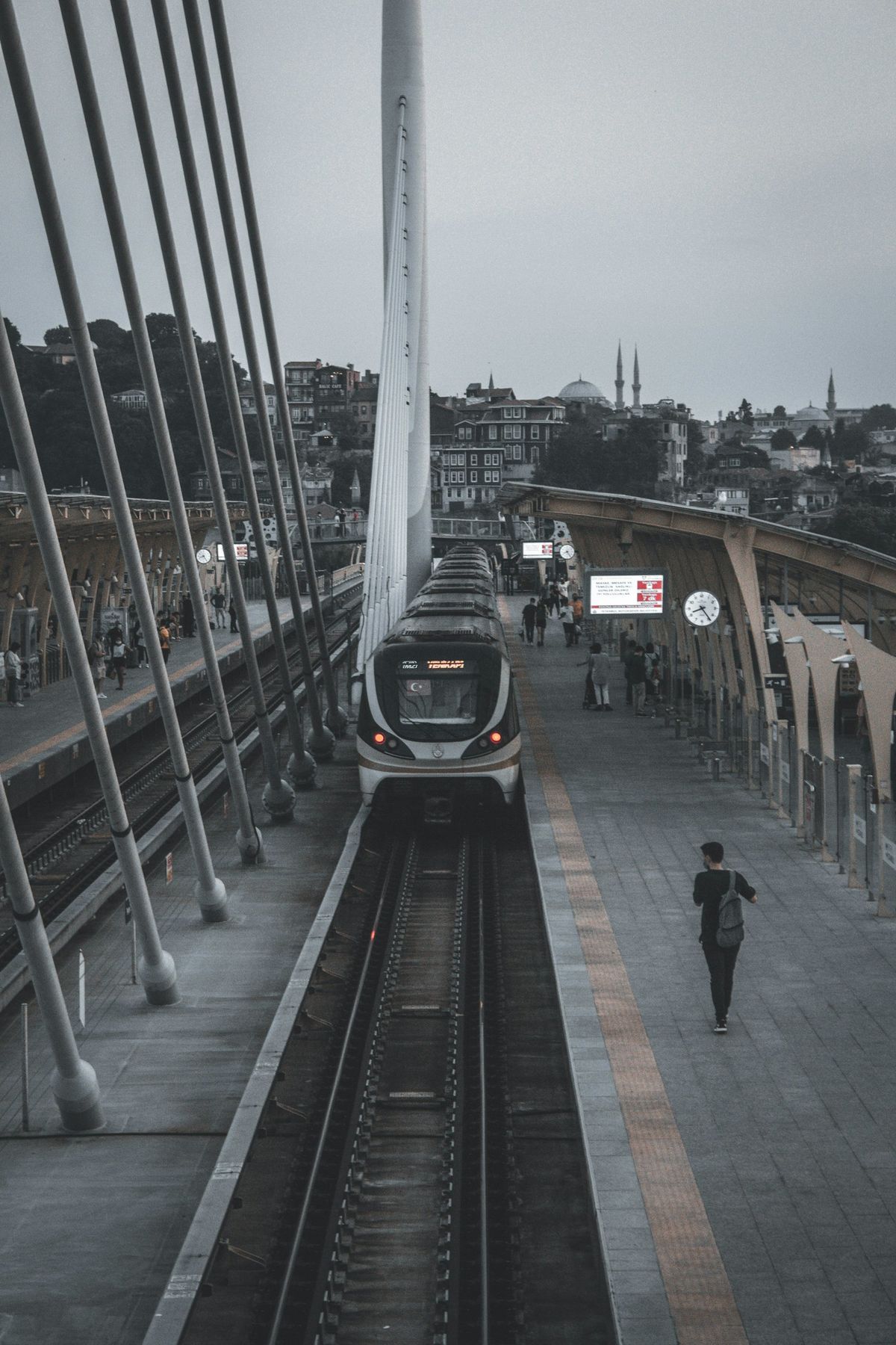 Train traveling down tracks next to a station in Istanbul