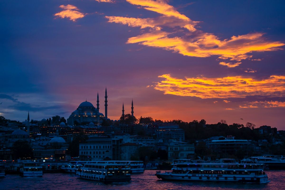 Sunset over Istanbul with ferries on the water near Galata Bridge