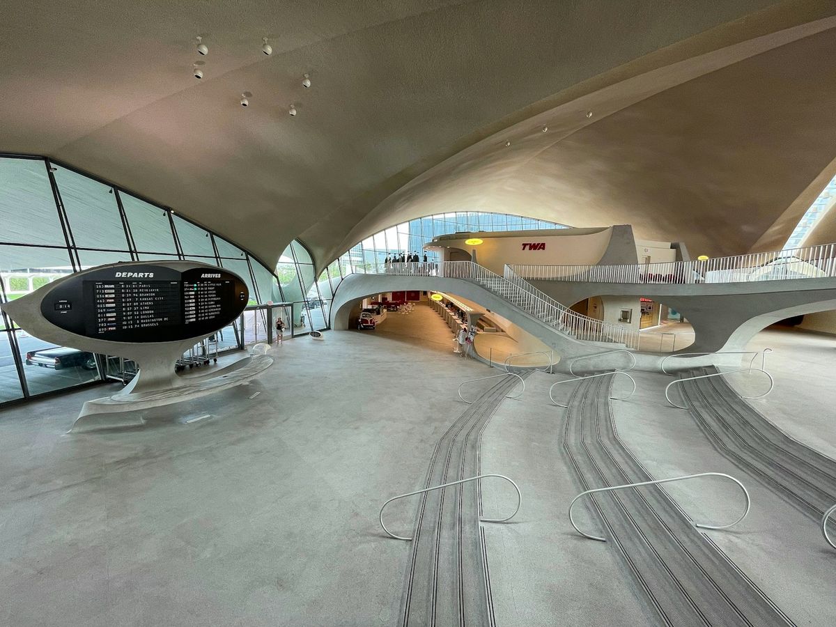 TWA Hotel curved walkway with iconic clock at JFK Airport