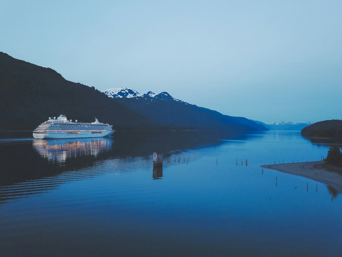 Cruise ship in the channel near Juneau Alaska with forested mountains behind