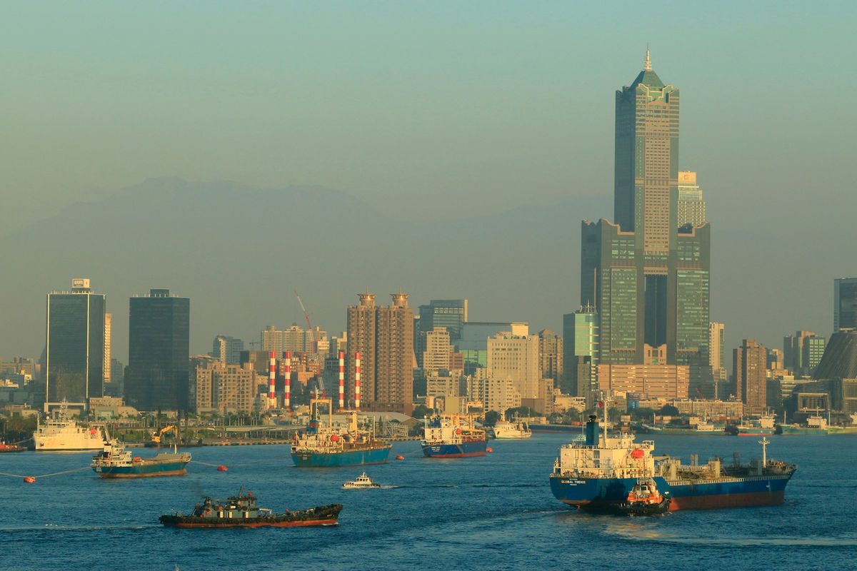 Boats in Kaohsiung harbour with the city skyline behind