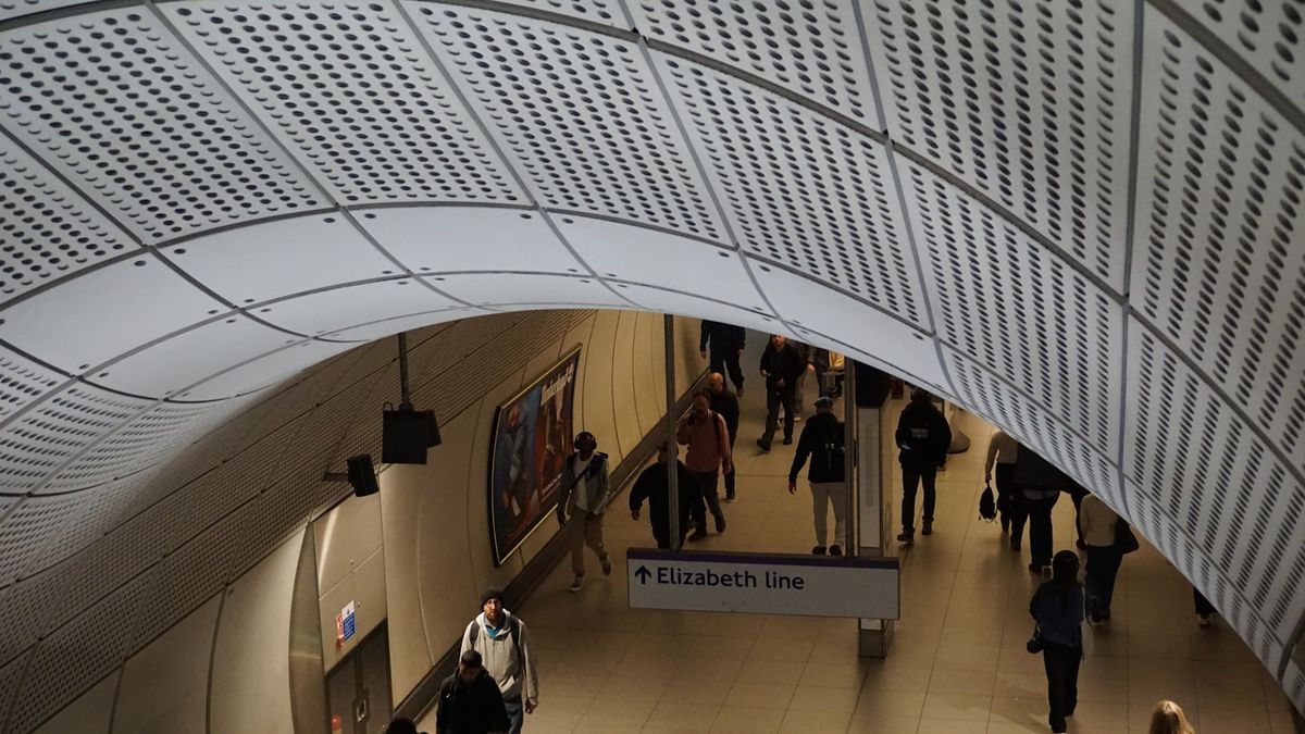 Passengers moving through a modern Elizabeth line underground station at Heathrow