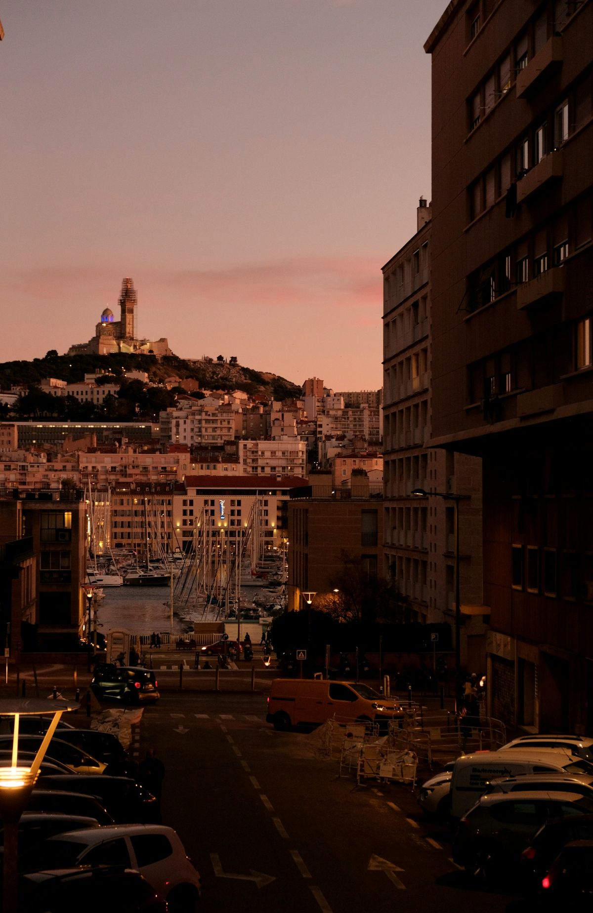 Marseille harbour with basilica silhouette at dusk